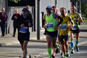 zdjęcie kolorowe: uczestnicy biegu maratońskiego na trasie