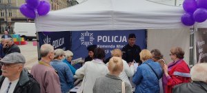 zdjęcie kolorowe: policjanci zajmujący się profilaktyka społeczna podczas spotkania z seniorami na katowickim rynku