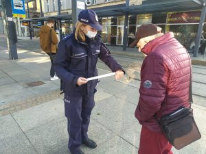 zdjęcie kolorowe: katowicka policjantka podczas rozmowy z mieszkańcami Katowic i pasażerami komunikacji miejskiej