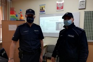 Zdjęcie kolorowe przedstawiające policjantów w klasie lekcyjnej.