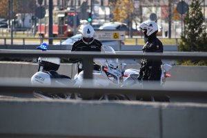 zdjęcie kolorowe: dwóch policjantów ruchu drogowego przy policyjnych motocyklach