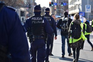 zdjęcie kolorowe: policjanci oddziału prewencji maszerujący przy zgromadzeniu