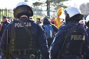 zdjęcie kolorowe: policjanci oddziału prewencji nadzorujący kibiców przybyłych na mecz