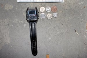 zdjęcie kolorowe: czarny zegarek i monety