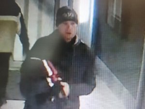 zdjęcie kolorowe: mężczyzna podejrzewany o kradzież z włamaniem ubrany w czarna czapkę, czarna kurtkę