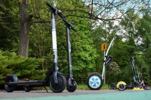 zdjęcie kolorowe: hulajnogi i urządzenia UTO zaparkowane na ścieżce rowerowej