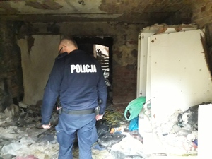 zdjęcie kolorowe: katowicki dzielnicowy kontrolujący jedno z pomieszczeń w pustostanie