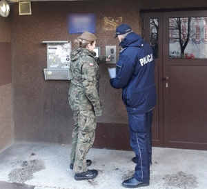 zdjęcie kolorowe: żołnierz WOT i policjant przy domofonie