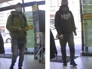 zdjęcie kolorowe: dwóch mężczyzn podejrzewanych o kradzież słodyczy. Z lewej mężczyzna ubrany w niebieskie spodnie jeansowe, musztardową kurtkę, czarna czapkę z daszkiem i maseczkę ochronna złażoną na twarz, z prawej mężczyzna ubrany czarne buty sportowe, czarne spodnie, czarna bluzę dresową z kapturem z białym napisem na piersi czarna czapkę z daszkiem i maseczkę ochronna założoną na twarz.