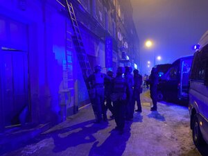 zdjęcie kolorowe: policyjni konterroryści przed kamienicą w której zabarykadował się mężczyzna