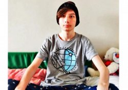 zdjęcie kolorowe: Przemysław Krol siedzący na łóżku z ubrana na głowie czapką