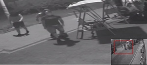 zdjęcie czarno białe: screen z monitoringu sklepowego przedstawiający zamazane sylwetki trzech mężczyzn podejrzewanych o pobicie