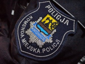 zdjęcie kolorowe: naszywka na mundur przedstawiająca herb Katowic i napis o treści Komenda Miejska Policji w Katowicach