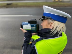 zdjęcie kolorowe: policjantka podczas kontroli prędkości pojazdu
