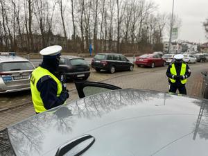 zdjęcie kolorowe: dwóch policjantów wydziału ruchu drogowego podczas kontroli drogowej
