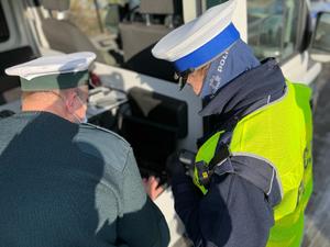 zdjęcie kolorowe: policjant katowickiej drogówki z inspektorem Wojewódzkiego Inspektoratu Transportu Drogowego w Katowicach podczas wspo9łnej służby