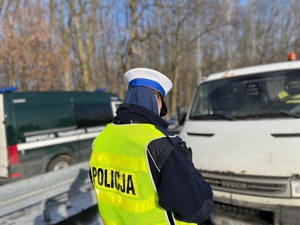 zdjęcie kolorowe: policjant katowickiej drogówki podczas kontroli drogowej pojazdu ciężarowego