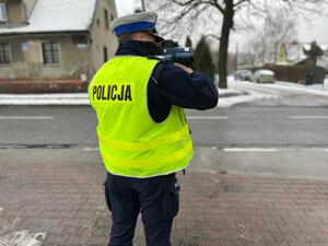zdjęcie kolorowe: policjant katowickiej drogówki wykonujący pomiar prędkości pojazdu