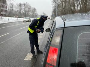 zdjęcie kolorowe: policjant katowickiej drogówki rozmawiający z kierującym samochodem osobowym o popełnionym przez niego wykroczeniu