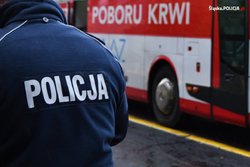 zdjęcie kolorowe: policjant przed ambulansem krwiodastwa