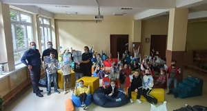 zdjęcie kolorowe:  Sierż. szt. Sylwia Michalak, asp. szt. Tomasz Sołtysiak oraz mł. asp. Mateusz Urbańczyk dzielnicowi z Komisariatu VII Policji w Katowicach podczas spotkania z uczniami uczęszczającymi na półkolonie