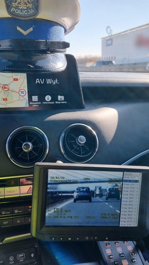 zdjęcie kolorowe: wideorejestrator w policyjnym radiowozie i policyjna czapka