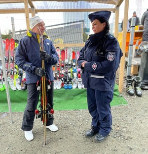 zdjęcie kolorowe: katowicka policjantka rozmawiająca na temat bezpieczeństwa na stoku z narciarzem