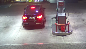 zdjęcie kolorowe:   granatowe BMW parkujące na stacji paliw