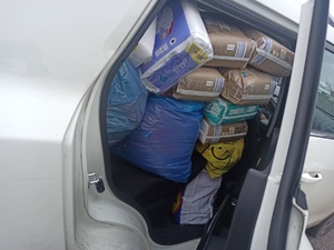 zdjęcie kolorowe: wypełniony po dach samochód z zebranymi dla uchodźców darami