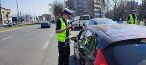 zdjęcie kolorowe: policjant ruchu drogowego podczas kontroli samochodu