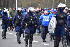 zdjęcie kolorowe: policjanci oddziału prewencji nadzorujący przemarsz kibiców Widzewa Łódź i Ruchu Chorzów na katowicki stadion