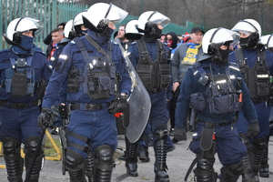 zdjęcie kolorowe: policjanci oddziału prewencji prowadzący kibiców Widzewa Łódź i Ruchu Chorzów przy katowickim stadionie