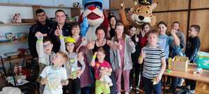 zdjęcie kolorowe: pamiątkowe zdjęcie policjantów oraz dzieci i kobiet z Ukrainy