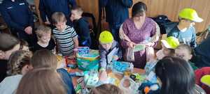 zdjęcie kolorowe: tłumaczka wraz z dziećmi przy stole z prezentami