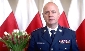 zdjęcie kolorowe: na tle polskich flag Komendant Główny Policji gen. insp. Jarosław Szymczyk