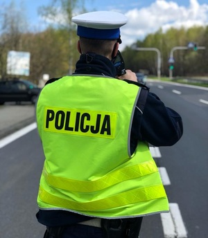 zdjęcie kolorowe: policjant katowickiej drogówki podczas kontroli prędkości pojazdu
