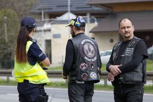 zdjęcie kolorowe:  policjantka katowickiej komendy wspólnie z dwoma członkami stowarzyszenie Moto Pistons Górny Śląsk podczas działań profilaktycznych