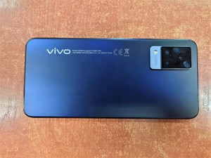 zdjęcie kolorowe: na blacie biurka położony telefon komórkowy marki VIVO