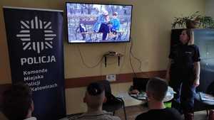 zdjęcie kolorowe: policjantka ogląda razem z ukraińską młodzieżą przygotowane przez Komendę Główną Policji materiały dotyczące handlu ludźmi
