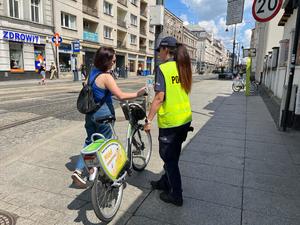 zdjęcie kolorowe: policjantka rozmawiająca z rowerzystką o bezpieczeństwie w ruchu drogowym