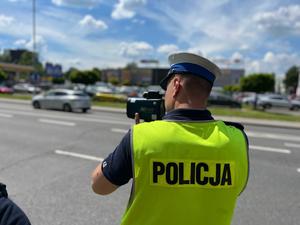 zdjęcie kolorowe: policjant katowickiej drogówki dokonujący pomiaru prędkości samochodu