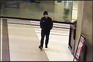 zdjęcie kolorowe: zrzut z monitoringu przedstawiający poczekalnie dworca kolejowego i mężczyznę ubranego w czarne spodnie, czarna bluzę z dresu i czarna czapkę