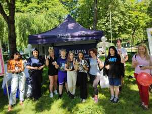 zdjęcie kolorowe: policjantka z uczestnikami festynu przed stoiskiem profilaktycznym katowickiej komendy