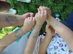 zdjęcie kolorowe: cztery ręce dzieci z odbitymi tatuażami Sznupka