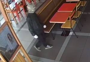 zdjęcie kolorowe: mężczyzna z założoną na twarz komiarką wchodzi do restauracji w Katowicach