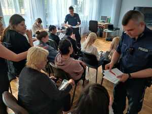 zdjęcie kolorowe:  sierż. szt. Kamil Sierny i sież. Piotr Sambor rozdający ulotki informacyjne podczas spotkania z uchodźcami