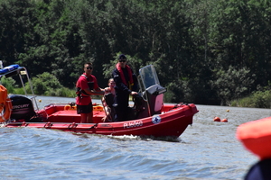 zdjęcie kolorowe: umundurowany policjant i ratownicy wopr