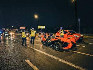 zdjęcie kolorwe: policjanci drogówki podczas kontroli pojazdów w czasie zlotu luksusowych aut