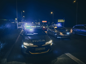 zdjęcie kolorowe: policyjne radiowozy ustawione na jezdni podczas kontroli samochodów osobowych