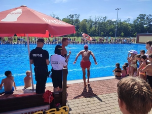 zdjęcie kolorowe: ratownicy wodni, policjanci oraz strażnicy miejscy podczas prelekcji na temat bezpieczeństwa nad wodą, która odbyła się na basenie miejskim